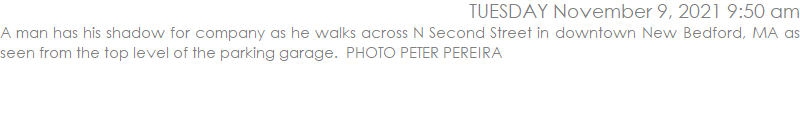 A man has his shadow for company as he walks across N Second Street in downtown New Bedford, MA as seen from the top level of the parking garage.  PHOTO PETER PEREIRA