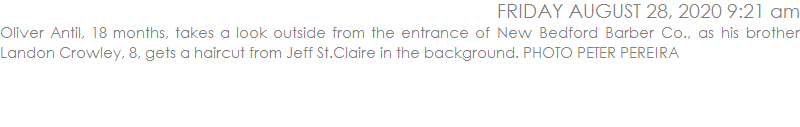 Oliver Antil, 18 months, takes a look outside from the entrance of New Bedford Barber Co., as his brother Landon Crowley, 8, gets a haircut from Jeff St.Claire in the background. PHOTO PETER PEREIRA