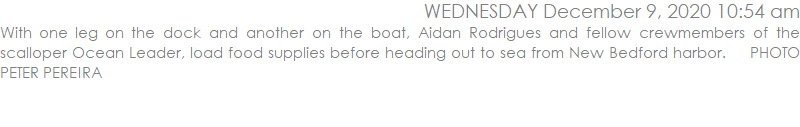 With one leg on the dock and another on the boat, Aidan Rodrigues and fellow crewmembers of the scalloper Ocean Leader, load food supplies before heading out to sea from New Bedford harbor.    PHOTO PETER PEREIRA