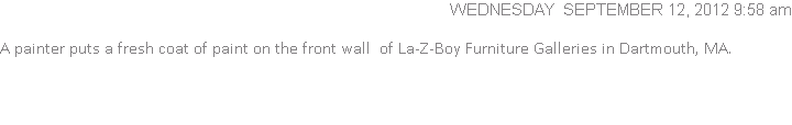  A painter puts a fresh coat of paint on the front wall  of La-Z-Boy Furniture Galleries in Dartmouth, MA.
