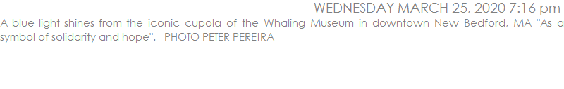 A blue light shines from the iconic cupola of the Whaling Museum in downtown New Bedford, MA 