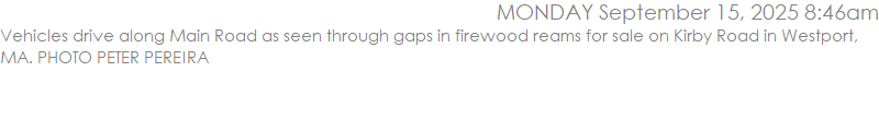 Vehicles drive along Main Road as seen through gaps in firewood reams for sale on Kirby Road in Westport, MA. PHOTO PETER PEREIRA