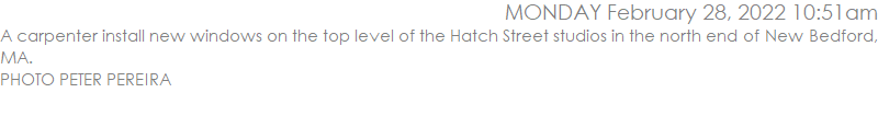 A carpenter install new windows on the top level of the Hatch Street studios in the north end of New Bedford, MA. PHOTO PETER PEREIRA