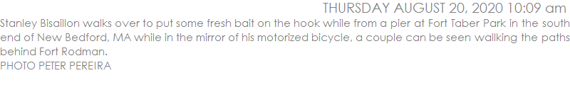 Stanley Bisaillon walks over to put some fresh bait on the hook while from a pier at Fort Taber Park in the south end of New Bedford, MA while in the mirror of his motorized bicycle, a couple can be seen wallking the paths behind Fort Rodman. 