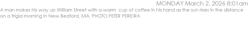 A man makes his way up William Street with a warm  cup of coffee in his hand as the sun rises in the distance on a frigid morning in New Bedford, MA. PHOTO PETER PEREIRA