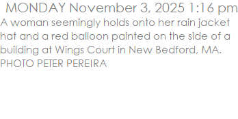 A woman seemingly holds onto her rain jacket hat and a red balloon painted on the side of a building at Wings Court in New Bedford, MA. PHOTO PETER PEREIRA