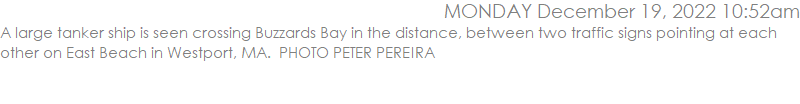A large tanker ship is seen crossing Buzzards Bay in the distance, between two traffic signs pointing at each other on East Beach in Westport, MA.  PHOTO PETER PEREIRA