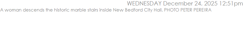 A woman descends the historic marble stairs inside New Bedford City Hall. PHOTO PETER PEREIRA