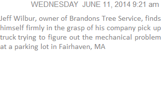 Jeff Wilbur, owner of Brandons Tree Service, finds himself firmly in the grasp of his company pick up truck trying to figure out the mechanical problem at a parking lot in Fairhaven, MA