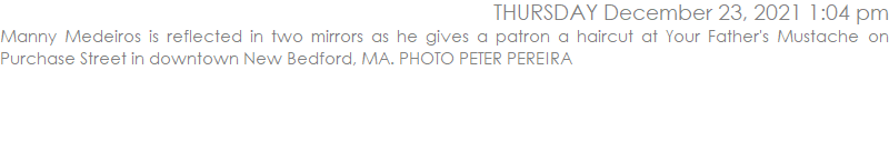 Manny Medeiros is reflected in two mirrors as he gives a patron a haircut at Your Father's Mustache on Purchase Street in downtown New Bedford, MA. PHOTO PETER PEREIRA