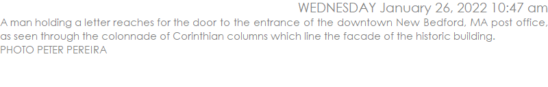 A man holding a letter reaches for the door to the entrance of the downtown New Bedford, MA post office, as seen through the colonnade of Corinthian columns which line the facade of the historic building. PHOTO PETER PEREIRA