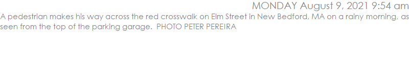 A pedestrian makes his way across the red crosswalk on Elm Street in New Bedford, MA on a rainy morning, as seen from the top of the parking garage.  PHOTO PETER PEREIRA