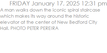 A man walks down the iconic spiral staircase which makes its way around the historic elevator at the center of New Bedford City Hall. PHOTO PETER PEREIRA