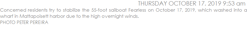 Concerned residents try to stabilize the 55-foot sailboat Fearless on October 17, 2019, which washed into a wharf in Mattapoisett harbor due to the high overnight winds. 