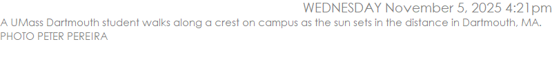 A UMass Dartmouth student walks along a crest on campus as the sun sets in the distance in Dartmouth, MA. PHOTO PETER PEREIRA