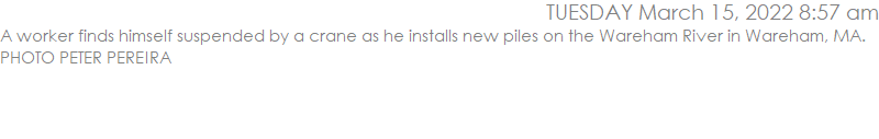 A worker finds himself suspended by a crane as he installs new piles on the Wareham River in Wareham, MA. PHOTO PETER PEREIRA