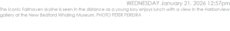 The iconic Fairhaven skyline is seen in the distance as a young boy enjoys lunch with a view in the Harborview gallery at the New Bedford Whaling Museum. PHOTO PETER PEREIRA