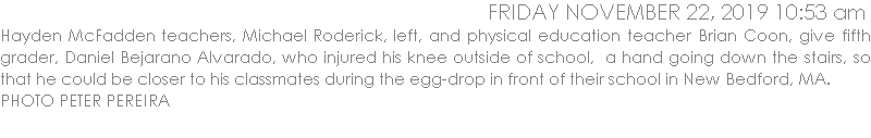Hayden McFadden teachers, Michael Roderick, left, and physical education teacher Brian Coon, give fifth grader, Daniel Bejarano Alvarado, who injured his knee outside of school,  a hand going down the stairs, so that he could be closer to his classmates during the egg-drop in front of their school in New Bedford, MA.