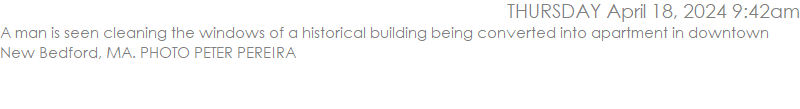 A man is seen cleaning the windows of a historical building being converted into apartment in downtown New Bedford, MA. PHOTO PETER PEREIRA