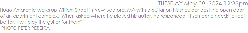 Hugo Amarante walks up William Street in New Bedford, MA with a guitar on his shoulder past the open door of an apartment complex.  When asked where he played his guitar, he responded 