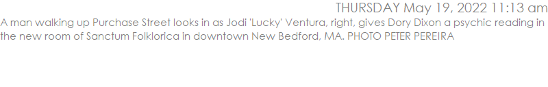 A man walking up Purchase Street looks in as Jodi 'Lucky' Ventura, right, gives Dory Dixon a psychic reading in the new room of Sanctum Folklorica in downtown New Bedford.