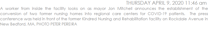 A worker from inside the facility looks on as mayor Jon Mitchell announces the establishment of the conversion of two former nursing homes into regional care centers for COVID-19 patients.  The press conference was held in front of the former Kindred Nursing and Rehabilitation facility on Rockdale Avenue in New Bedford, MA. PHOTO PETER PEREIRA