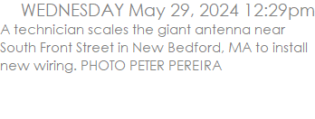 A technician scales the giant antenna near South Front Street in New Bedford, MA to install new wiring. PHOTO PETER PEREIRA