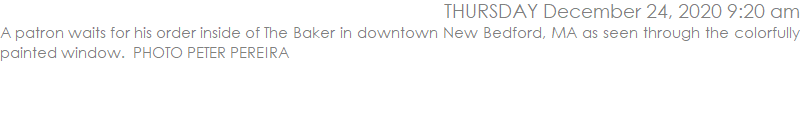 A patron waits for his order inside of The Baker in downtown New Bedford, MA as seen through the colorfully painted window.  PHOTO PETER PEREIRA 