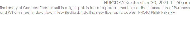 Tim Landry of Comcast finds himself in a tight spot, inside of a precast manhole at the intersection of Purchase and William Street in downtown New Bedford, installing new fiber optic cables.  PHOTO PETER PEREIRA