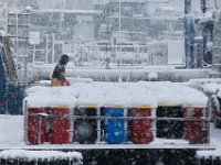 Fuel Man bargeman is seen refuelling a fishing boat docked in New Bedford as heavy snow falls across the region. PHOTOS PETER PEREIRA