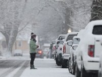 A woman stands with a warm cup in hand as she looks on as snow falls s across the region. PHOTOS PETER PEREIRA