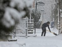 A man shovels the sidewalk on Armour Street in New Bedford as a snow storm sweeps across the region. PHOTOS PETER PEREIRA