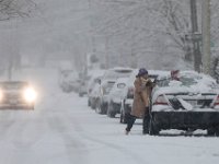 A woman removes the snow from her vehicle on Maple Street in New Bedford as a snow storm sweeps across the region. PHOTOS PETER PEREIRA