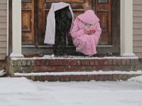 A woman is bundled up in front of her home in New Bedford during the first snowfall of the year. PHOTOS PETER PEREIRA