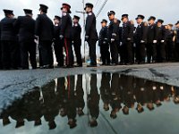 Firefighters are reflected in a pudle as they line up outside of the Hathaway Community Home for Funerals in Somerset, for the wake of Somerset Fire Chief Scott Jepson.  [ PETER PEREIRA/THE STANDARD-TIMES/SCMG ]