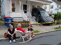 Byron Ford is joined by his daughter Lauren Amaral, left, and granddaughter Leiah Amaral, 11, after he was left stunned when a vehicle backed up onto the porch of his home on Maple Street in New Bedford.  Mr. Byron who normally sits on his porch at this time of day, decided not to today.  The motorist was parallel parking and hit the accelerator instead of break, no one was hurt.