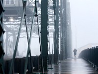 A man makes his way across the Fairhaven bridge on a foggy morning jog.