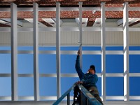 Benjamin Perez paints the trellis work of a residence in Fairhaven.