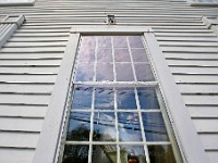 Elias Alves-Sobrinho of R. P. Valois paints the window trims of the new Westport Historical Society building at the former Bell School House in Westport.