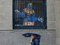 A woman walks past a scary Jack in the Box installed behind a window on the Union Square building on Union Street in New Bedford.