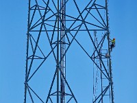 A technician scales the giant antenna near South Front Street in New Bedford to install new wiring.