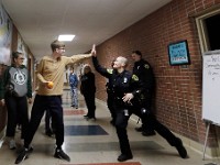 Dartmouth Middle School student James high-fives Dartmouth Police elementary resource officer, Amanda Tavares, during a game of Bocce ball in the school's hallway.