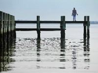 Bernadette Souza stands on a dock in the south end of New Bedford with head pointed up and arms open.  When asked, Bernadette responded 'I was offering a prayer for all of the world".