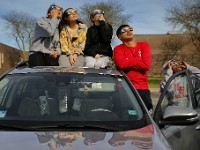 New Bedford High School students look at the solar eclipse from the the sunroof of their vehicle in New Bedford, MA on April 8, 2024.