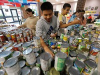 Alex Calel Mateo, 13, and fellow Normandin Middle School eighth graders sort the over three thousand cans they collected throughout the school year to give to the needy for Thanksgiving.