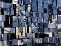 A woman walks up Centre Street in downtown New Bedford as seen through the gap in an art installation installed on the edge of Route 18.