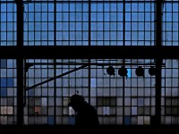 A worker walks past the historic glass pane wall of the former Revere Copper plant in New Bedford which is now the Shoreline Offshore maritime yard.