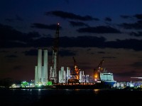 A ship carrying a tower for the Vinyeard Wind offshore wind farm is seen docked on the New Bedford Maritime Terminal as the sun sets.