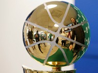 Fans are reflected on the Celtics 2024 NBA Champion trophy as they take photos with it during its stop at the Mass State Lottery office at the Industrial Park in New Bedford.