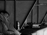 Jeffrey smokes a cigarette in an effort to stay warm.  Three men's recent change in fortuunes have forced them to make their home under the 195 overpass due to circumstances that they could not have imagined. No living homeless, they live on a day to day basis hoping for a change in their luck.